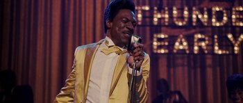 Movie still from “Dreamgirls” (2006), directed by Bill Condon – A man in a yellow jacket is singing into a microphone; Close Up shot, Low angle