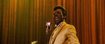 Movie still from “Dreamgirls” (2006), directed by Bill Condon – A man in a suit and tie singing into a microphone; Close Up shot, Low angle