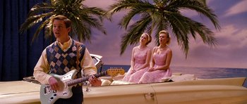 Movie still from “Dreamgirls” (2006), directed by Bill Condon – A couple of women sitting next to each other on top of a car; Wide shot, Over the shoulder angle