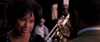 Movie still from “Dreamgirls” (2006), directed by Bill Condon – A person with a band in the background; Close Up shot, Over the shoulder angle