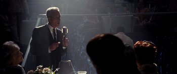 Movie still from “Dreamgirls” (2006), directed by Bill Condon – A man in a suit and tie holding a microphone; Medium shot, Over the shoulder angle