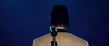 Movie still from “Dreamgirls” (2006), directed by Bill Condon – The back view of a man with a microphone; Close Up shot, Over the shoulder angle