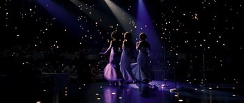 Movie still from “Dreamgirls” (2006), directed by Bill Condon – A group of three women standing on a dance floor; Wide shot, Low angle
