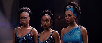 Movie still from “Dreamgirls” (2006), directed by Bill Condon – A group of three women standing next to each other; Close Up shot, Over the shoulder angle