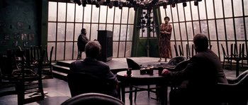 Movie still from “Dreamgirls” (2006), directed by Bill Condon – A woman standing on a stage in front of a microphone; Wide shot, Over the shoulder angle