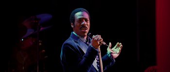Movie still from “Dreamgirls” (2006), directed by Bill Condon – A man holding a microphone while wearing a suit and tie; Close Up shot, Low angle