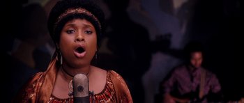 Movie still from “Dreamgirls” (2006), directed by Bill Condon – A woman singing into a microphone in front of a wall; Close Up shot, Low angle