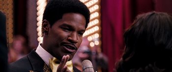 Movie still from “Dreamgirls” (2006), directed by Bill Condon – A person holding a microphone; Close Up shot, Over the shoulder angle