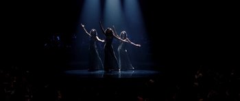 Movie still from “Dreamgirls” (2006), directed by Bill Condon – A group of three women are performing on a stage; Wide shot, High angle