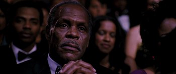 Movie still from “Dreamgirls” (2006), directed by Bill Condon – An older man with his hands clasped in front of a woman; Close Up shot, Low angle