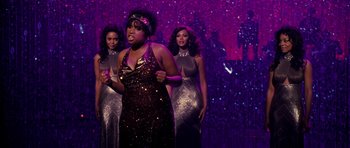 Movie still from “Dreamgirls” (2006), directed by Bill Condon – A group of women standing next to each other on a stage; Medium shot, Over the shoulder angle