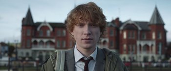 Movie still from “Frank” (2014), directed by Lenny Abrahamson – A man with a red hair and a suit and tie; Close Up shot, Low angle