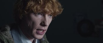 Movie still from “Frank” (2014), directed by Lenny Abrahamson – A person with red hair; Close Up shot, Over the shoulder angle