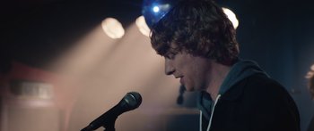 Movie still from “Frank” (2014), directed by Lenny Abrahamson – A man with a microphone in his ear; Close Up shot, Over the shoulder angle