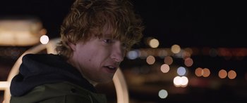 Movie still from “Frank” (2014), directed by Lenny Abrahamson – A person with curly hair; Close Up shot, Over the shoulder angle