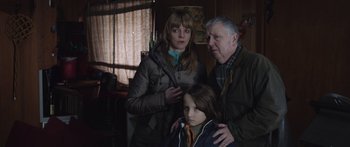 Movie still from “Frank” (2014), directed by Lenny Abrahamson – A woman and a man standing next to a young girl; Medium shot, Low angle