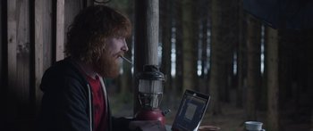 Movie still from “Frank” (2014), directed by Lenny Abrahamson – A man sitting in front of a laptop computer; Medium shot, Over the shoulder angle