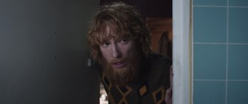 Movie still from “Frank” (2014), directed by Lenny Abrahamson – A man with long red hair wearing a sweater; Medium shot, Low angle