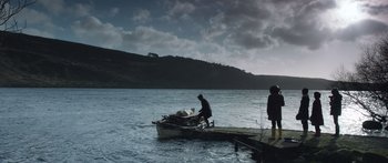 Movie still from “Frank” (2014), directed by Lenny Abrahamson – Two people standing on a dock near a boat; Extreme Wide shot, Low angle