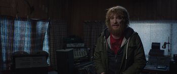 Movie still from “Frank” (2014), directed by Lenny Abrahamson – A man with long red hair and a red beard; Medium shot, Over the shoulder angle