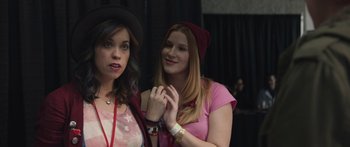 Movie still from “Frank” (2014), directed by Lenny Abrahamson – Two young women standing next to each other; Close Up shot, Over the shoulder angle