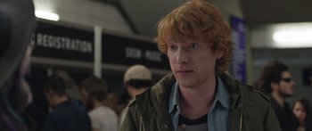 Movie still from “Frank” (2014), directed by Lenny Abrahamson – A person wearing a jacket; Close Up shot, Over the shoulder angle