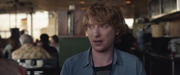 Movie still from “Frank” (2014), directed by Lenny Abrahamson – A person wearing a blue shirt; Close Up shot, Over the shoulder angle