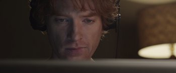 Movie still from “Frank” (2014), directed by Lenny Abrahamson – A person wearing headphones looking at a computer screen; Close Up shot, Low angle