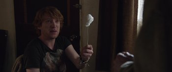 Movie still from “Frank” (2014), directed by Lenny Abrahamson – A man holding a white object in his hand; Medium shot, Over the shoulder angle