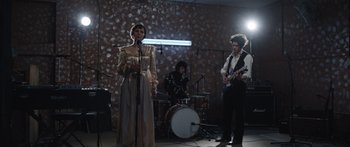 Movie still from “Frank” (2014), directed by Lenny Abrahamson – A group of people that are performing on a stage; Wide shot, Low angle