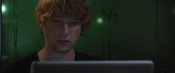 Movie still from “Frank” (2014), directed by Lenny Abrahamson – A man with red hair is looking at a laptop; Close Up shot, Low angle