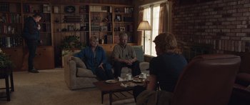 Movie still from “Frank” (2014), directed by Lenny Abrahamson – A group of people sitting around a living room; Wide shot, Over the shoulder angle