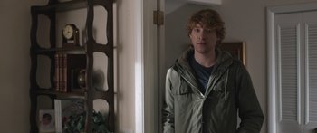 Movie still from “Frank” (2014), directed by Lenny Abrahamson – A man standing in front of an open door; Medium shot, Over the shoulder angle