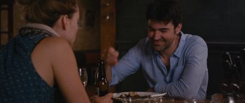 Movie still from “Drinking Buddies” (2013), directed by Joe Swanberg – A man sitting at a dinner table with a woman; Medium shot, Over the shoulder angle