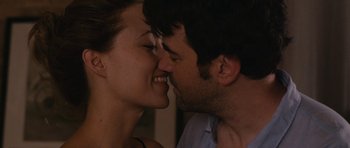 Movie still from “Drinking Buddies” (2013), directed by Joe Swanberg – A person kissing a person on the cheek; Close Up shot, Over the shoulder angle