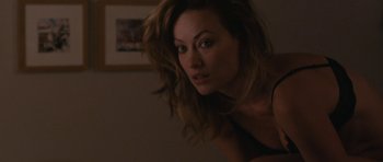 Movie still from “Drinking Buddies” (2013), directed by Joe Swanberg – A beautiful woman with long brown hair posing for the camera; Close Up shot, Over the shoulder angle