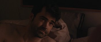 Movie still from “Drinking Buddies” (2013), directed by Joe Swanberg – A person laying in a bed; Close Up shot, Over the shoulder angle