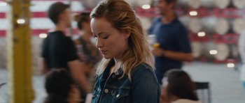 Movie still from “Drinking Buddies” (2013), directed by Joe Swanberg – A young woman with long blonde hair wearing a jean jacket; Close Up shot, Over the shoulder angle