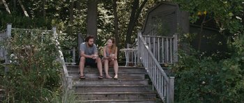 Movie still from “Drinking Buddies” (2013), directed by Joe Swanberg – A man and a woman sitting on the steps of a house; Wide shot, High angle