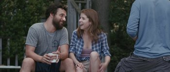Movie still from “Drinking Buddies” (2013), directed by Joe Swanberg – A man and a woman sitting next to each other on the ground; Medium shot, Over the shoulder angle