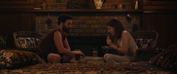 Movie still from “Drinking Buddies” (2013), directed by Joe Swanberg – A man and a woman sitting in front of a fireplace; Wide shot, High angle