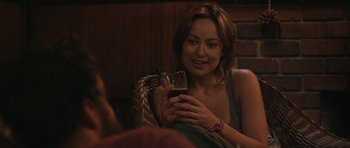 Movie still from “Drinking Buddies” (2013), directed by Joe Swanberg – A woman sitting in a chair holding a glass of wine; Close Up shot, Over the shoulder angle