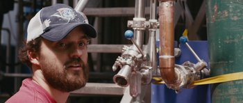 Movie still from “Drinking Buddies” (2013), directed by Joe Swanberg – A person wearing a hat; Close Up shot, Low angle