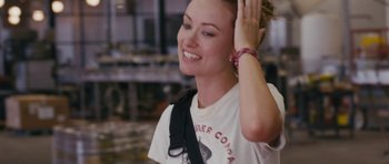 Movie still from “Drinking Buddies” (2013), directed by Joe Swanberg – A smiling woman with her hands behind her head; Close Up shot, Over the shoulder angle