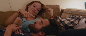 Movie still from “Drinking Buddies” (2013), directed by Joe Swanberg – A man and a woman laying on a couch; Close Up shot, Over the shoulder angle