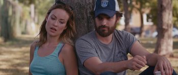 Movie still from “Drinking Buddies” (2013), directed by Joe Swanberg – A man and a woman sitting next to a tree; Close Up shot, Over the shoulder angle
