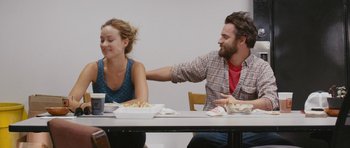 Movie still from “Drinking Buddies” (2013), directed by Joe Swanberg – A man and a woman sitting at a table with food; Medium shot, Over the shoulder angle
