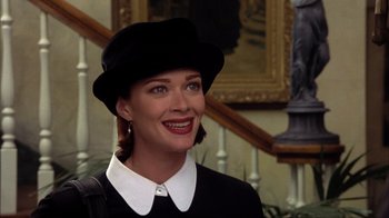 Movie still from “Dumb and Dumber” (1994), directed by Peter Farrelly – A woman wearing a black hat and a white collar shirt; Close Up shot, Over the shoulder angle