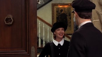 Movie still from “Dumb and Dumber” (1994), directed by Peter Farrelly – A woman wearing a black hat and a white collar shirt; Medium shot, Over the shoulder angle