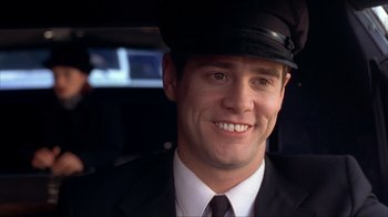 Movie still from “Dumb and Dumber” (1994), directed by Peter Farrelly – A man in a suit and hat smiling for the camera; Close Up shot, Low angle